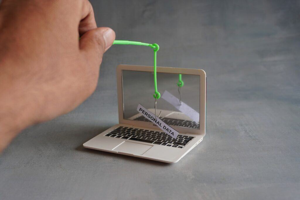 Closeup image of laptop and fish hook with text PERSONAL DATA.