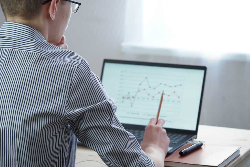 The young man looks at the laptop screen. Remote work, online education. The latest technologies,